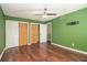 Bedroom with wood floors and green walls with 3 closets, showing multiple shuttered doors at 4 Quail Run, Decatur, GA 30035