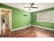 Bedroom featuring wood floors, green walls, and window; showing access to hallway and closets at 4 Quail Run, Decatur, GA 30035