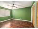 Bedroom with green walls, wood flooring, and shuttered-door closets and a window with blinds at 4 Quail Run, Decatur, GA 30035