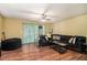 Relaxing living room featuring hardwood floors, a ceiling fan, and a comfortable dark sofa at 4 Quail Run, Decatur, GA 30035
