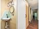 Hallway powder room with sliding barn door and updated wall-mounted sink with glass-tile backsplash at 4 Quail Run, Decatur, GA 30035