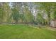 Spacious backyard with lush green grass, trees, and a storage shed at 567 Shiloh Nw Rd, Kennesaw, GA 30144
