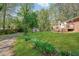 Wide backyard lawn with lush green grass, garden beds, and a shed at 567 Shiloh Nw Rd, Kennesaw, GA 30144