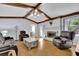 Spacious living room with a painted brick fireplace, exposed wood beams, and cozy furniture at 567 Shiloh Nw Rd, Kennesaw, GA 30144