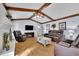 Cozy living room featuring exposed beams, wood floors, a brick fireplace, and comfortable seating at 567 Shiloh Nw Rd, Kennesaw, GA 30144