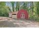 Outbuilding featuring a red barn-style shed with white doors and a smaller storage shed attached at 567 Shiloh Nw Rd, Kennesaw, GA 30144