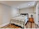 Cozy bedroom with light-colored walls, hardwood floors, a floral quilt, and a small wooden nightstand at 973 Meadow Club Ct, Suwanee, GA 30024