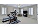 A well-lit exercise room with a ceiling fan, treadmill, exercise bike, and a TV at 973 Meadow Club Ct, Suwanee, GA 30024