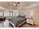 Spacious bedroom featuring a tray ceiling, wood floors, and a large window with natural light at 973 Meadow Club Ct, Suwanee, GA 30024