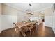 Bright dining area with hardwood floors, decorative wainscoting, stylish light fixture, and large wooden table at 1599 Benham Dr, Snellville, GA 30078