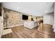 Finished basement with large screen TV, modern brick wall, and small arcade game at 1599 Benham Dr, Snellville, GA 30078
