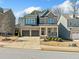 Charming two-story home boasts a brick and blue facade, manicured landscaping, and a two-car garage at 1599 Benham Dr, Snellville, GA 30078