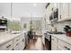 Well-appointed kitchen with white cabinets, stainless steel appliances, a center island, and hardwood floors at 1599 Benham Dr, Snellville, GA 30078