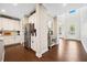 Modern kitchen boasts a large island, white cabinetry, hardwood floors, and open access to the entry foyer at 1599 Benham Dr, Snellville, GA 30078