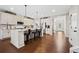 Bright kitchen with stainless steel appliances, white cabinets, island with bar stool seating, and hardwood flooring at 1599 Benham Dr, Snellville, GA 30078