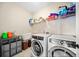 Functional laundry room equipped with modern washer, dryer, and ample storage space at 1599 Benham Dr, Snellville, GA 30078