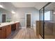 Primary bathroom with double sink, large tub, glass enclosed shower and hardwood floors at 7686 Brazos Trl, Fairburn, GA 30213
