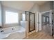 Bathroom featuring a large tub, separate shower and hardwood floors at 7686 Brazos Trl, Fairburn, GA 30213