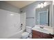 Bathroom with shower/tub combo, white tile, and vanity with modern fixtures at 7686 Brazos Trl, Fairburn, GA 30213