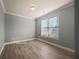 Neutral bedroom offers a bright window, gray walls, and hardwood flooring at 7686 Brazos Trl, Fairburn, GA 30213