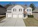 Charming two-story brick home featuring a three-car garage and well-manicured lawn at 7686 Brazos Trl, Fairburn, GA 30213