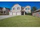 Charming two-story home with brick facade, three-car garage, and lush green lawn at 7686 Brazos Trl, Fairburn, GA 30213