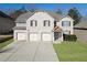 Charming two-story brick home featuring a three-car garage and well-manicured lawn at 7686 Brazos Trl, Fairburn, GA 30213