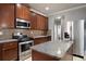 Kitchen featuring stainless steel appliances, granite countertops, an island, and dark wood cabinetry at 7686 Brazos Trl, Fairburn, GA 30213