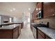 Open kitchen featuring granite countertops, stainless steel appliances, and wooden cabinets at 7686 Brazos Trl, Fairburn, GA 30213