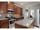 This kitchen features granite countertops, stainless steel appliances, and dark wood cabinetry at 7686 Brazos Trl, Fairburn, GA 30213