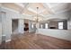 Open concept space showcasing coffered ceilings, wood floors, and seamless flow to the kitchen at 7686 Brazos Trl, Fairburn, GA 30213