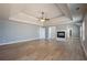Spacious main bedroom featuring a fireplace, hardwood floors and modern ceiling fan at 7686 Brazos Trl, Fairburn, GA 30213