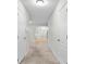 Bright hallway with carpet, leading to open living space with chandelier and stair access at 905 Magnolia Gardens Walk, Mcdonough, GA 30253