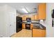 Functional kitchen with black appliances, granite countertop, and wooden cabinets provides ample storage at 905 Magnolia Gardens Walk, Mcdonough, GA 30253