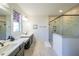 Bright bathroom featuring double sinks, a marble-tiled shower with a glass door, and modern fixtures at 171 Echols Bnd, Hiram, GA 30141