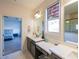 Bathroom with double vanity, large mirror, window with blind, and a view into the main bedroom at 171 Echols Bnd, Hiram, GA 30141