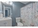 Bathroom features a white vanity with framed mirror, toilet and butterfly shower curtain at 3268 Rivermist Cv, Decatur, GA 30034