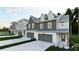 Charming townhomes with modern farmhouse design, each featuring an attached garage and individual driveway at 210 Sharon Ln, Loganville, GA 30052