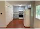 Galley kitchen featuring painted cabinets, a white subway tile backsplash, and wood floors at 2921 Oakwilde Ct, Snellville, GA 30039