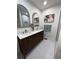 Modern bathroom featuring dual sinks, arched mirrors, and stylish herringbone tile flooring at 1403 Centra Villa Dr, Atlanta, GA 30311