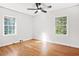 A cozy bedroom with hardwood floors, a ceiling fan, and natural light from two windows at 1403 Centra Villa Dr, Atlanta, GA 30311