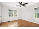 A cozy bedroom with hardwood floors, a ceiling fan, and natural light from two windows at 1403 Centra Villa Dr, Atlanta, GA 30311