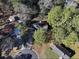 An aerial shot showcases a house with dark roof surrounded by trees and nestled in a quiet neighborhood at 2931 Oakwilde Ct, Snellville, GA 30039