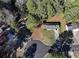 An aerial view shows a well-maintained home with a long driveway surrounded by lush greenery at 2931 Oakwilde Ct, Snellville, GA 30039