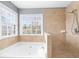 Inviting bathroom with a large bathtub, separate shower, and natural light at 310 Mulberry Manor Ct, Johns Creek, GA 30005