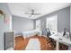 Cozy bedroom with hardwood flooring, a ceiling fan, and a well-lit desk area at 310 Mulberry Manor Ct, Johns Creek, GA 30005