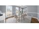 Light-filled dining area with white chairs, wood floors, and views of the neighborhood at 310 Mulberry Manor Ct, Johns Creek, GA 30005