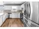 Modern kitchen featuring stainless steel appliances, bright lighting, and wood flooring at 310 Mulberry Manor Ct, Johns Creek, GA 30005