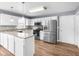 Modern kitchen with stainless steel appliances, white cabinetry, and wood floors at 310 Mulberry Manor Ct, Johns Creek, GA 30005