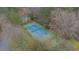 Aerial view of a well-maintained tennis court with green fencing, surrounded by trees providing shade and privacy at 310 Mulberry Manor Ct, Johns Creek, GA 30005